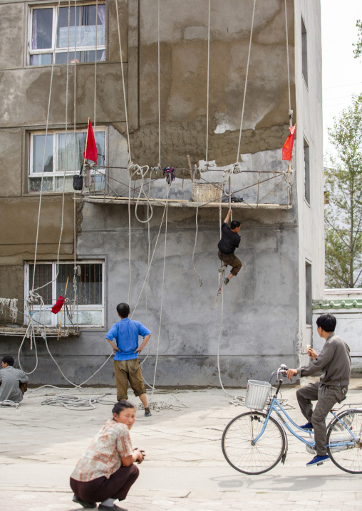 North Korean workmen on a dangerous scaffolding, South Hamgyong, Hamhung, North Korea