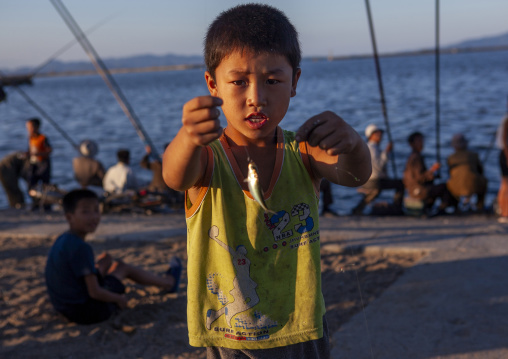 North Korean child boy showing fish he catched, Kangwon Province, Wonsan, North Korea