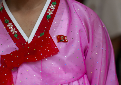North Korean woman in pink choson-ot with a Kim il Sung badge, DGC, Pyongyang, North Korea