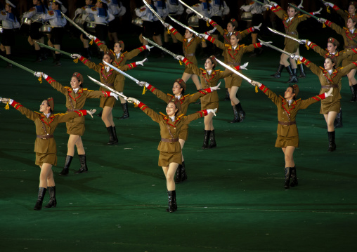 Women dressed as soldiers dancing with swords during the Arirang, DGC, Pyongyang, North Korea