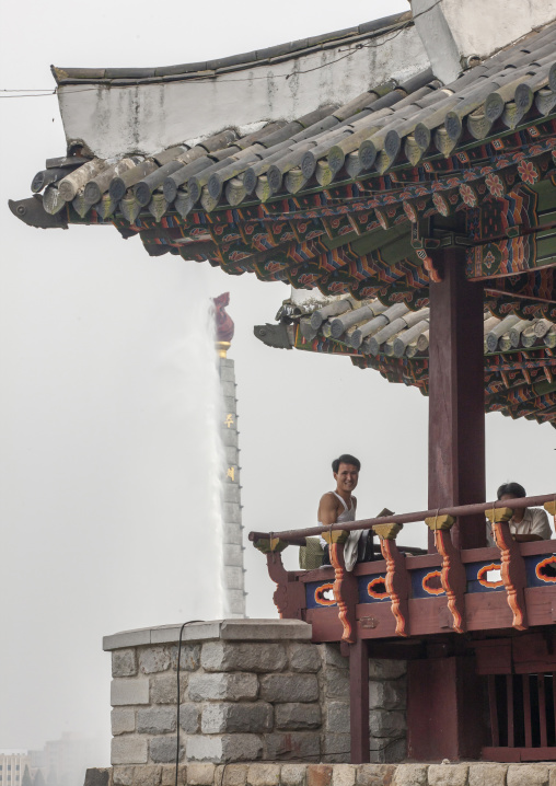 North Korean man under a pagoda in front of the Juche tower, DGC, Pyongyang, North Korea