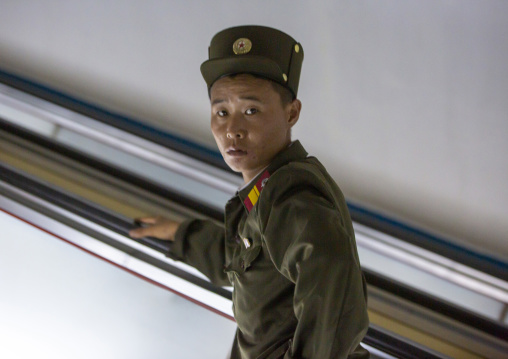 North Korean soldier using escalator leading to the subway station, DGC, Pyongyang, North Korea