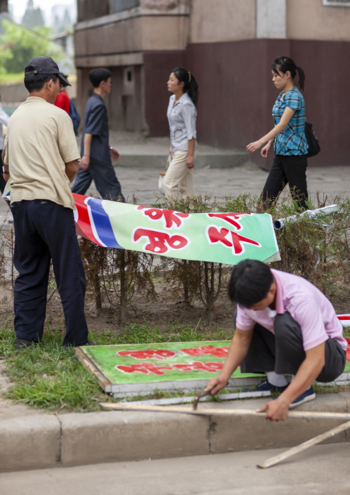 North korean men preparing propaganda billboards, DGC, Pyongyang, North Korea