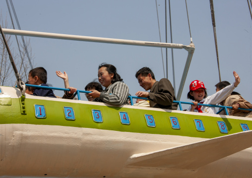 People having fun on a plane attraction in Taesongsan funfair, DGC, Pyongyang, North Korea
