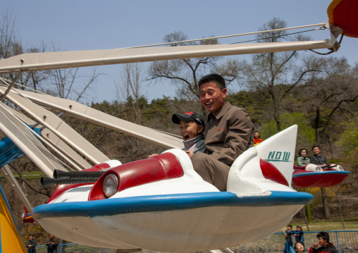 People having fun on a flying saucer attraction in Taesongsan funfair, DGC, Pyongyang, North Korea