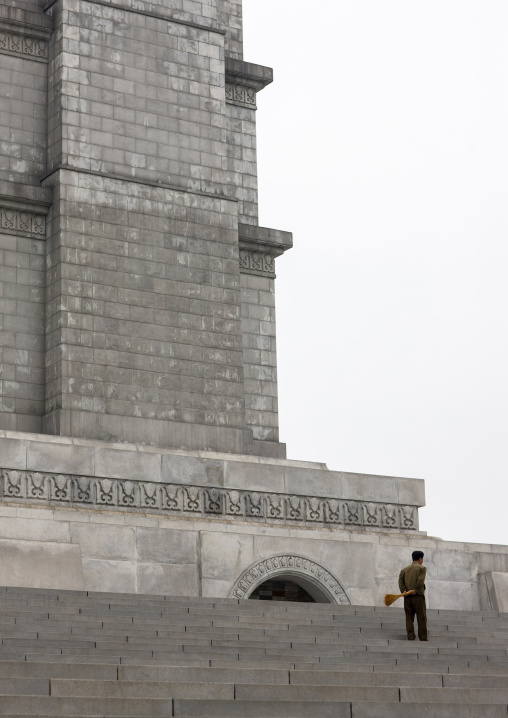 North Korean man with a broom at the bottom of the Juche tower, DGC, Pyongyang, North Korea