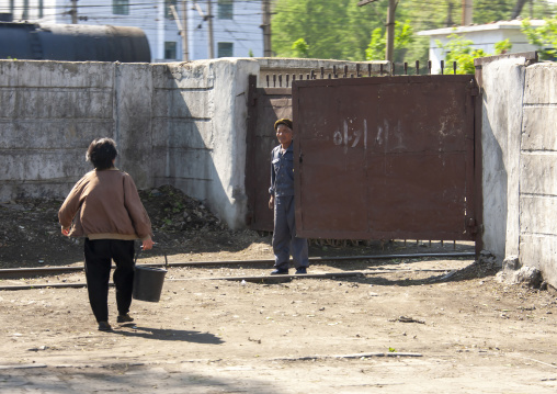 North korean people at a rusty metal gate, DGC, Pyongyang, North Korea