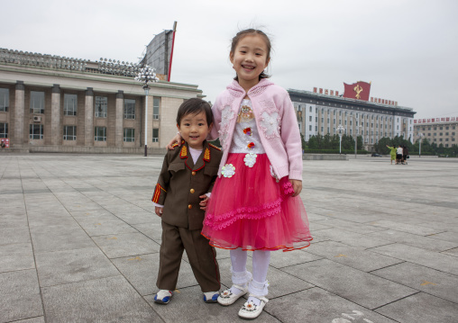 Boy dressed in soldier with his sister on Kim il Sung square, DGC, Pyongyang, North Korea