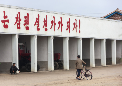 Garage for farm vehicles with a slogan on the top, South Hamgyong, Hamhung, North Korea
