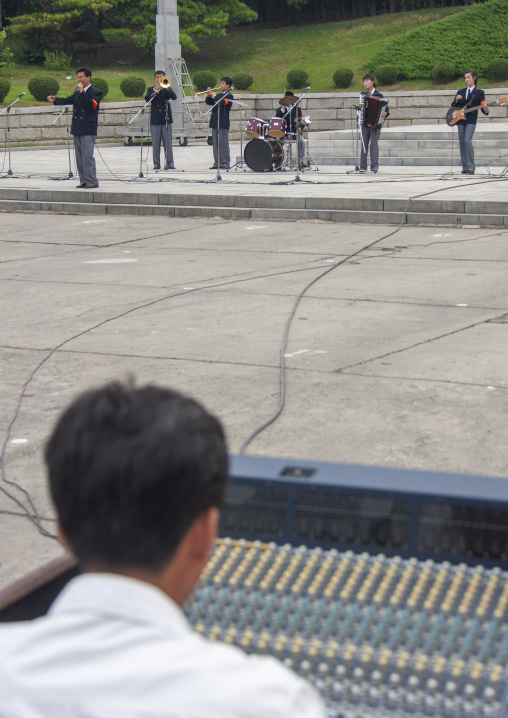 People listening to a band playing music on national day in the street, DGC, Pyongyang, North Korea