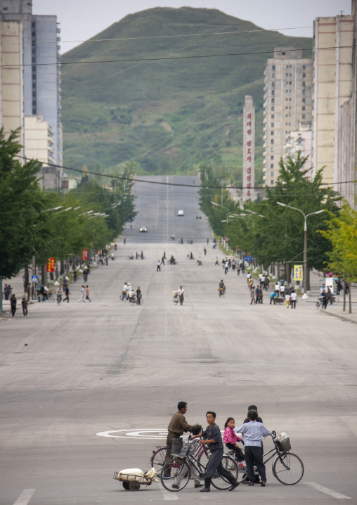 North korean people crossing a large avenue with trees, North Hwanghae, Kaesong, North Korea