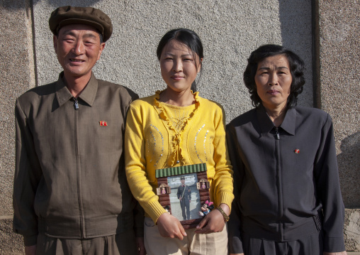 North Korean family with a picture of the son in the army, North Hamgyong, Jung Pyong Ri, North Korea