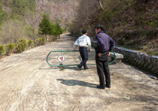North korean men removing fence on the road, North Hamgyong, Chilbosan, North Korea