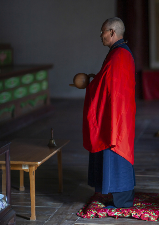 Monk praying in Pohyon-sa Korean buddhist temple, Hyangsan county, Mount Myohyang, North Korea