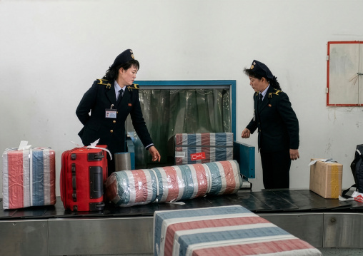 North Korean police women collecting luggages in Sunan international airport, DGC, Pyongyang, North Korea
