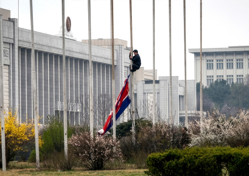 North korean man removing a north korean flag from a pole, DGC, Pyongyang, North Korea