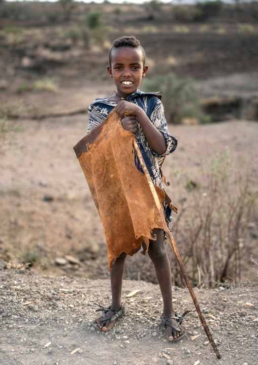 Ethiopain boy wearing a traditional clothing made with animal skin, Amhara Region, Lalibela, Ethiopia