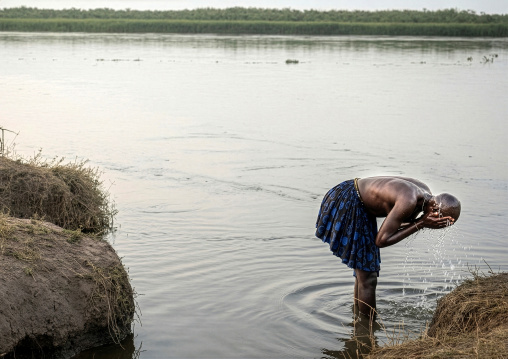 Mundari tribe woman washing her face in river Nile, Central Equatoria, Terekeka, South Sudan