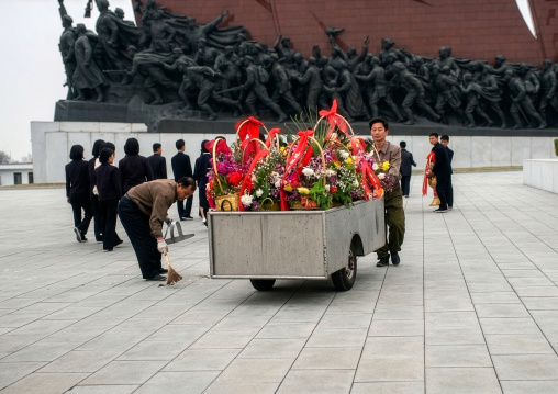 People removing flowers in the Grand monument, DGC, Pyongyang, North Korea