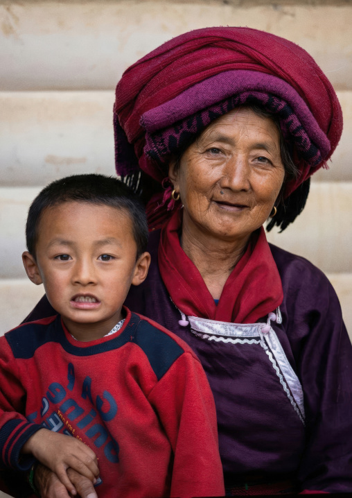 Yi ethnic minority grand mother with boy in traditional clothes, Yongsheng, Yunnan Province, China