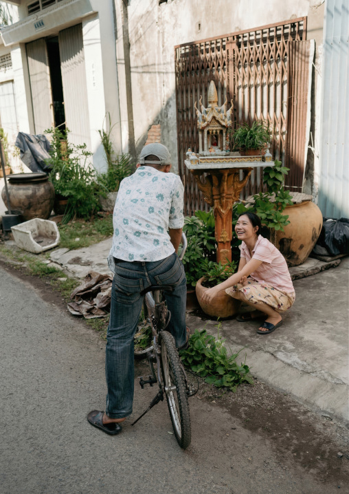 Man on a bicycle speaking to a woman, Phnom Penh province, Phnom Penh, Cambodia