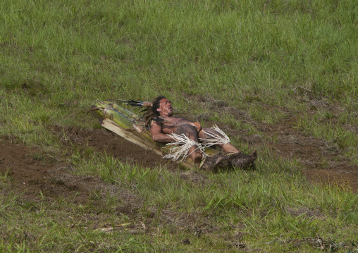 Man on banana trunk during haka pei competition during tapati festival, Easter Island, Hanga Roa, Chile