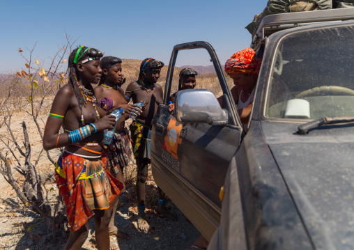 Muhacaona tribe women taking water from tourists, Cunene Province, Oncocua, Angola