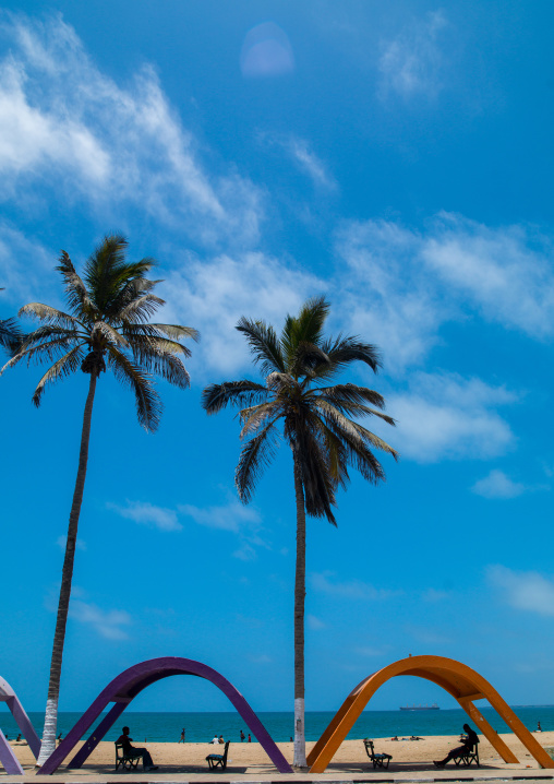 Shelters against sun on the beach with palm trees, Namibe Province, Namibe, Angola