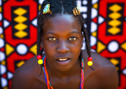 Portrait of a mudimba tribe woman in front of a colorful printed cloth, Cunene Province, Cahama, Angola