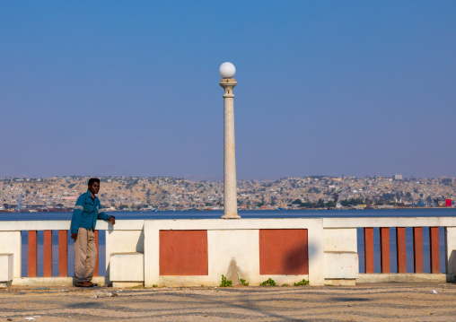 Angolan man leaning on fence, Benguela Province, Lobito, Angola