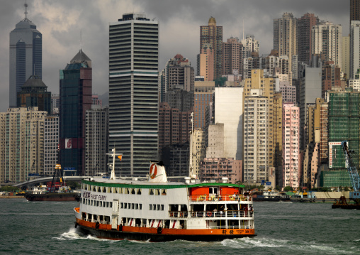 Ferry Crossing Harbour Withskyscrapers In Background, Hong Kong, China