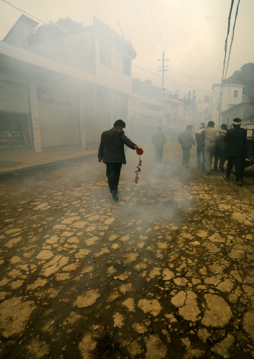 Man Holding Firecrackers During A Funeral Procession, Yuanyang, Yunnan Province, China