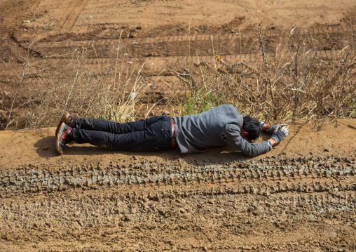 A tibetan buddhist believer on the kora pilgrim muddy path in Shachong monastery, Qinghai Province, Wayaotai, China