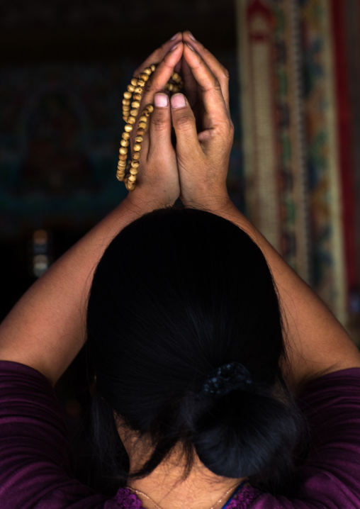 Tibetan pilgrim woman praying in Rongwo monastery, Tongren County, Longwu, China