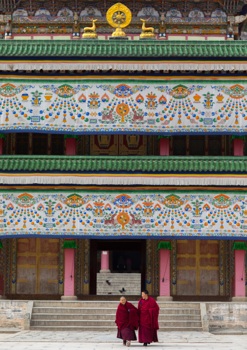 Tibetan monks coming out of a temple in Labrang monastery, Gansu province, Labrang, China