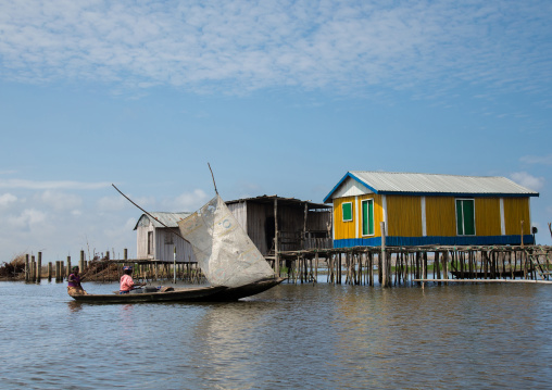 Benin, West Africa, Ganvié, boat passing in front of the stilt village on lake nokoue