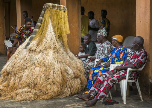 Benin, West Africa, Porto-Novo, men speaking to a zangbeto guardian of the night spirit in the royal palace