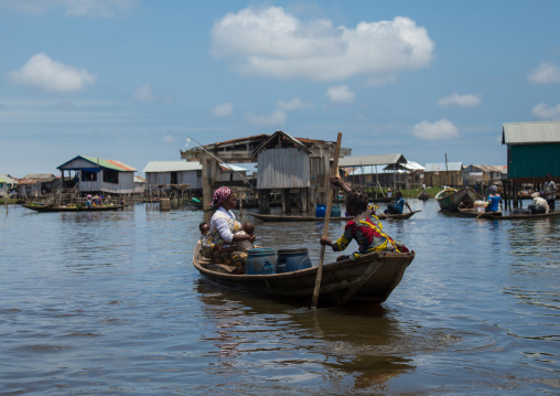 Benin, West Africa, Ganvié, boat passing in front of the stilt village on lake nokoue