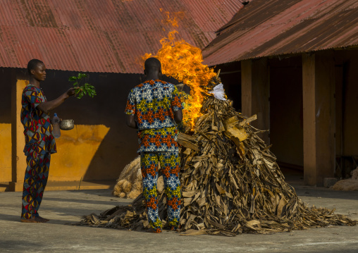 Benin, West Africa, Porto-Novo, men putting fire to a zangbeto guardian of the night in the royal palace
