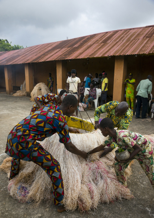 Benin, West Africa, Porto-Novo, men showing there is nobody inside the zangbeto guardian of the night in the royal palace