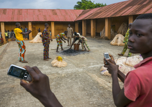 Benin, West Africa, Porto-Novo, men collecting ashes of a zangbeto guardian of the night in the royal palace