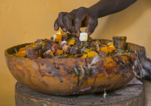 Benin, West Africa, Bonhicon, kagbanon bebe voodoo priest putting sugar on an altar during a voodoo ceremony