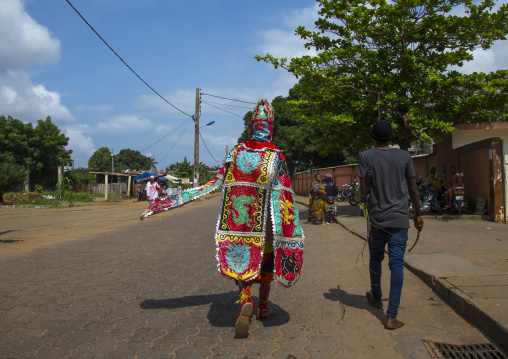 Benin, West Africa, Porto-Novo, egoun egoun spirit of the deads walking in the street with his guide to ask money to people