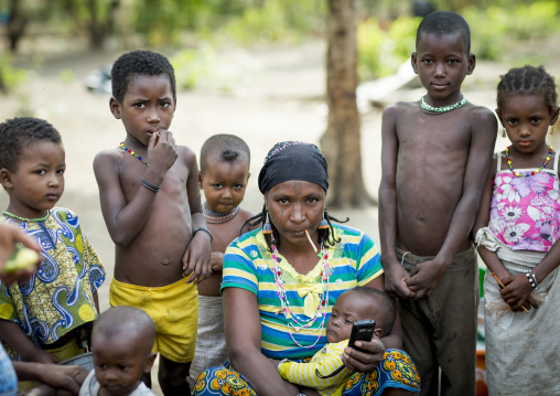 Benin, West Africa, Gossoue, a tatooed fulani peul tribe woman holding a mobile phone surrended by children