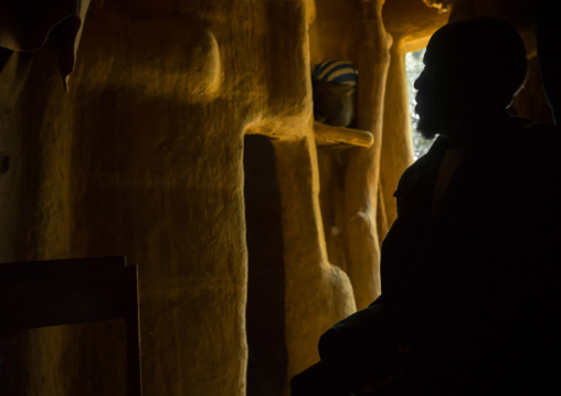 Benin, West Africa, Boukoumbé, silhouette of mr kouagou maxon in his traditional tata somba house