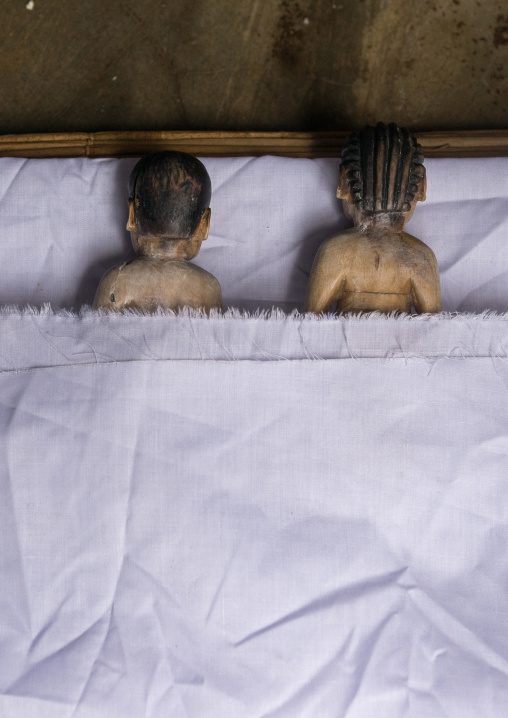 Benin, West Africa, Bopa, miss hounyoga putting in a bed the carved wooden figures made to house the soul of her dead twins