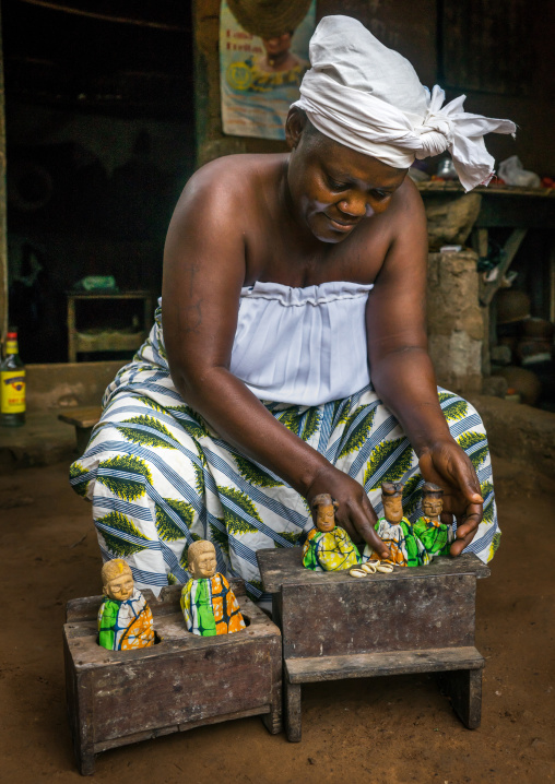 Benin, West Africa, Bopa, miss ablossi putting the carved wooden figures of her five dead twins in their box for daytime