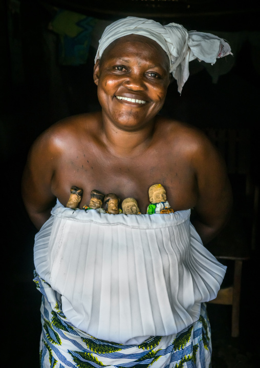 Benin, West Africa, Bopa, miss ablossi carrying the carved wooden figures of her five dead twins