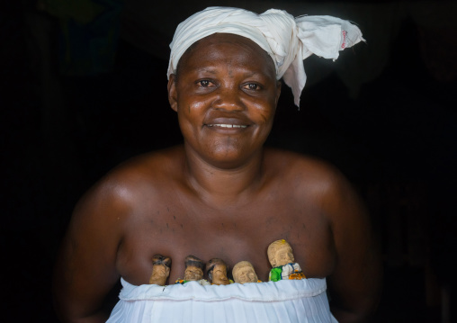 Benin, West Africa, Bopa, miss ablossi carrying the carved wooden figures of her five dead twins