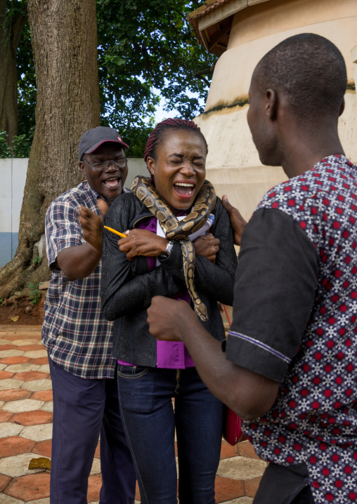 Benin, West Africa, Ouidah, woman screaming as a man puts a snake around her neck in the python temple